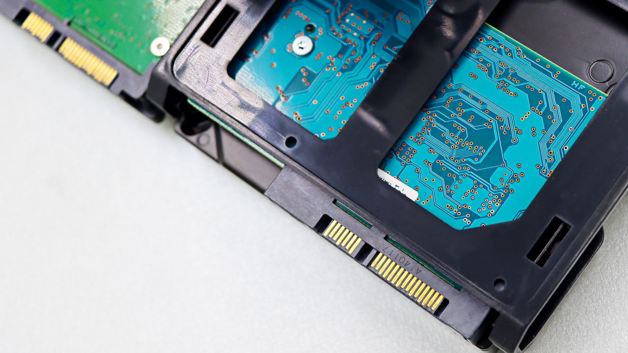 Două discuri de 2,5 inch așezate unul peste altul, cu mufa SATA și placa electronică la vedere